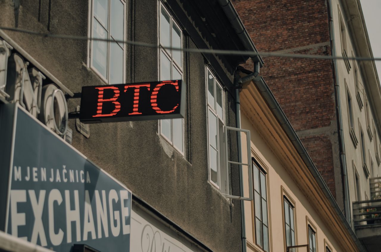Home Exterior of a building featuring a prominent BTC and exchange sign, indicating a cryptocurrency location.