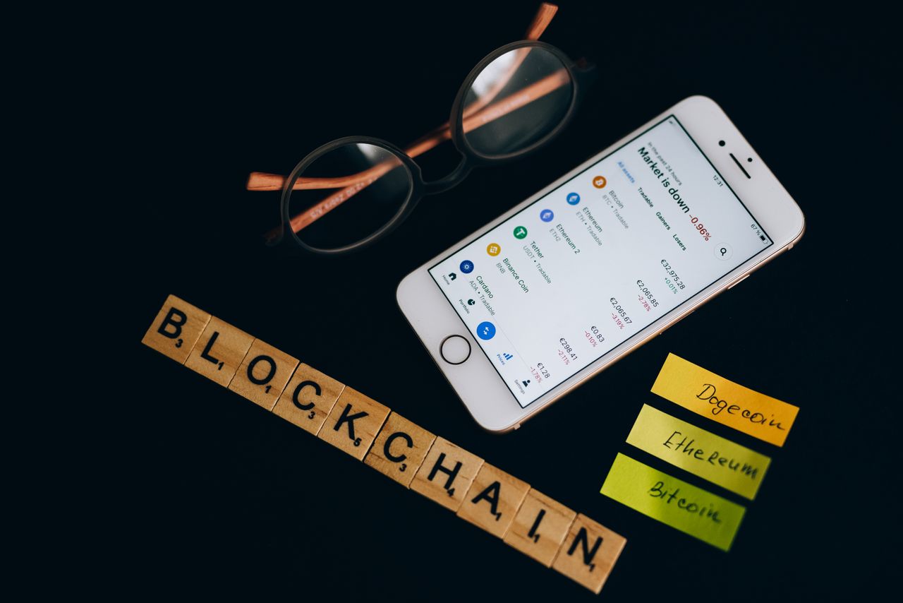 Home Smartphone displaying cryptocurrency market data alongside blockchain concept elements.